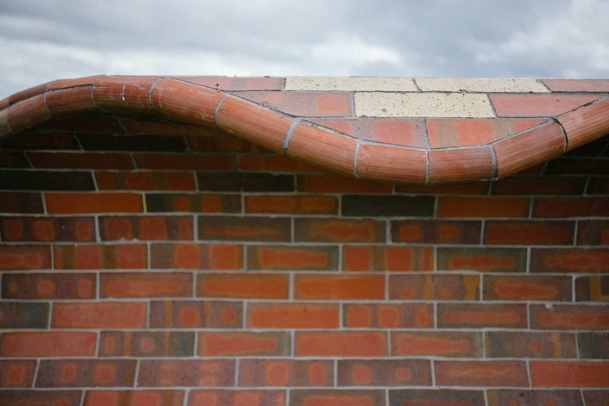 Detail view of a brick sculpture in the shape of a wave