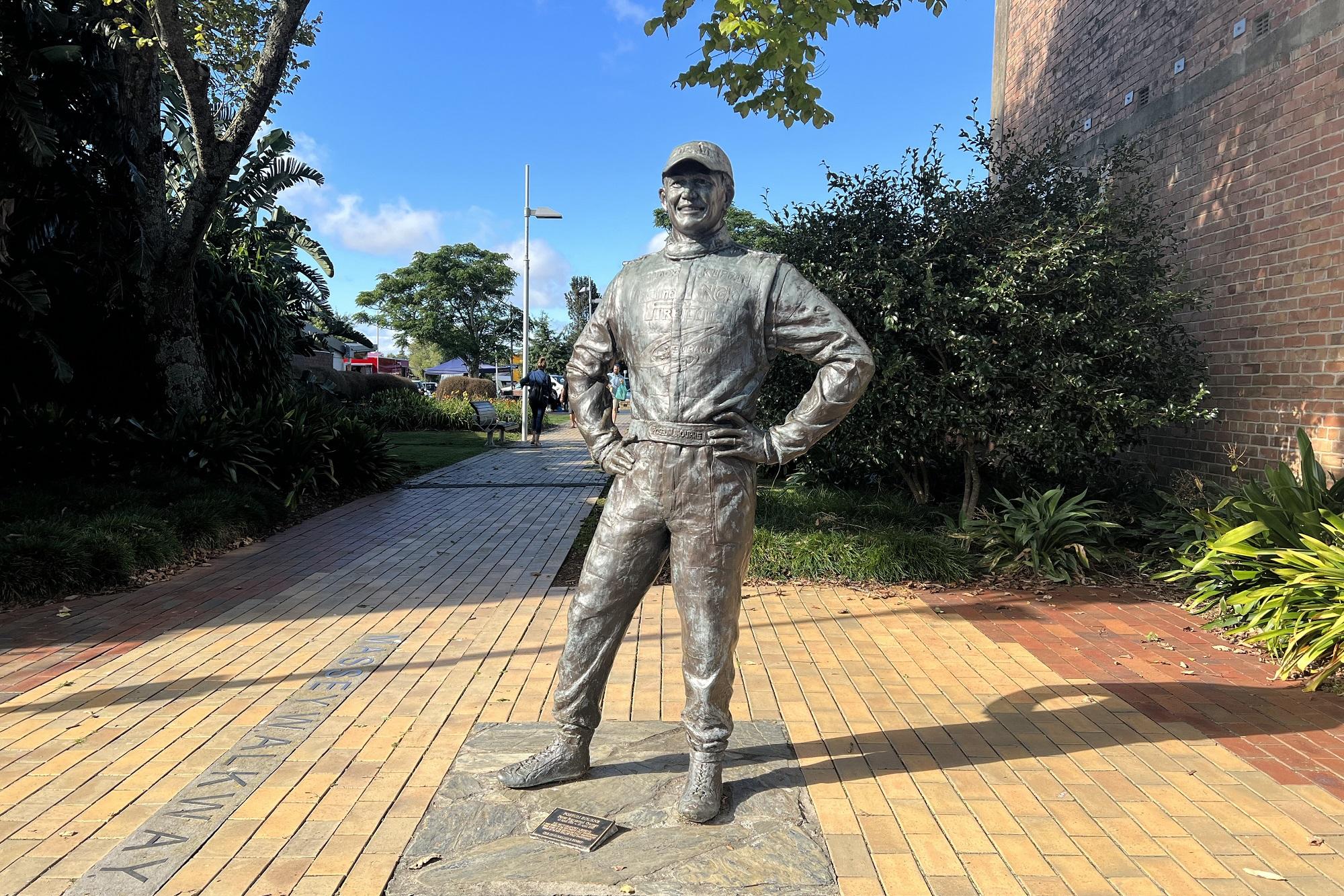 A life size statue of Possum Bourne in a brick alley
